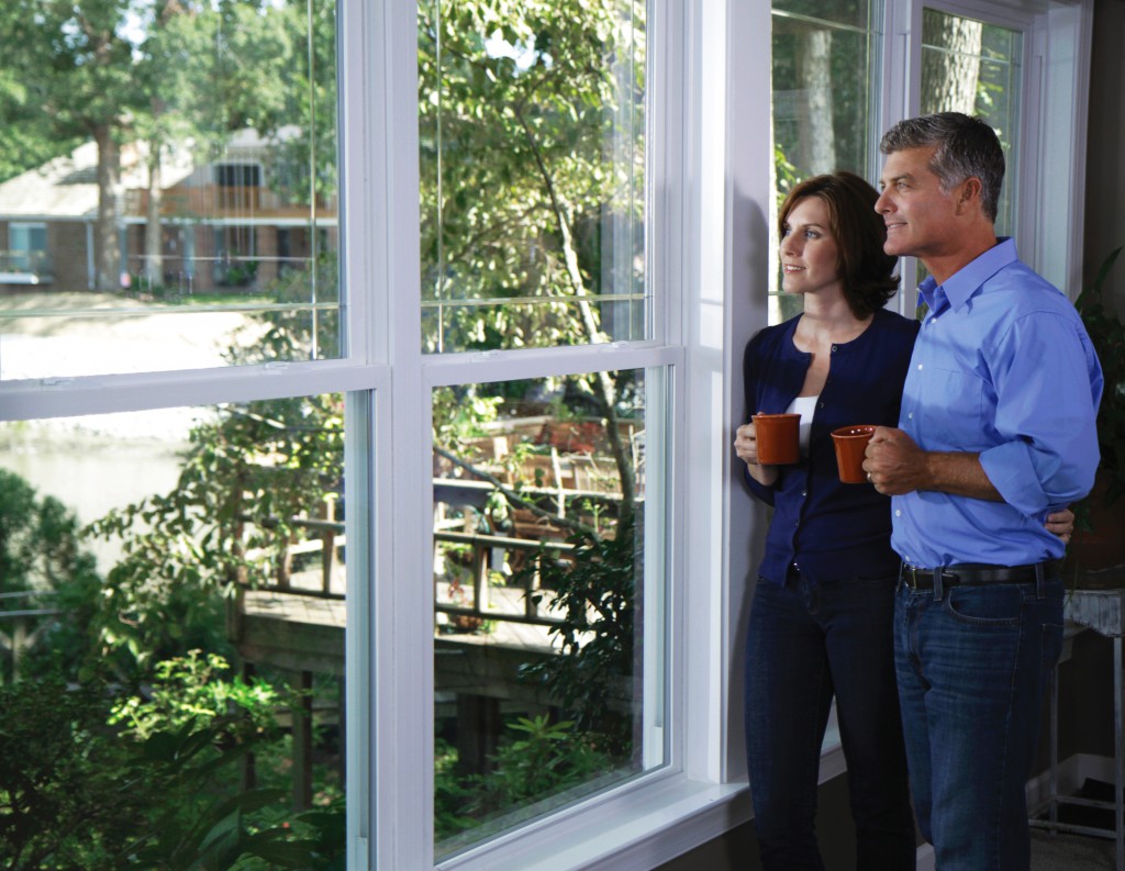 homeowners enjoying the view from their new replacement windows in their Long Island home