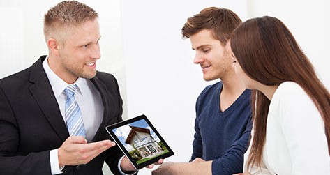 Real Estate Agent Showing A House To Potential Buyers On A IPad