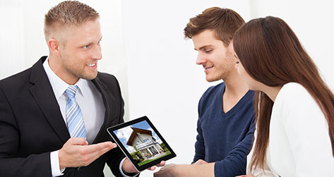 Home - Unified Home Remodeling Real Estate Agent Showing A House To Potential Buyers On A IPad