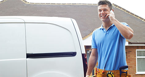 Guy In A Blue Shirt Smiling While On The Phone