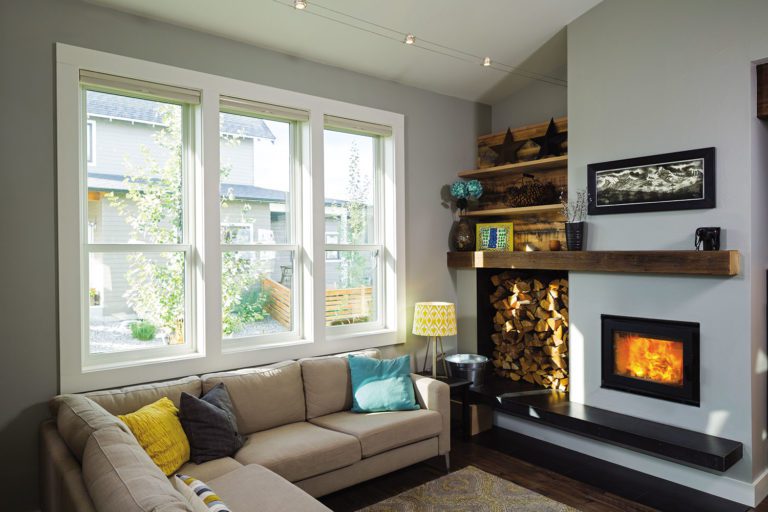 Double hung windows in a family room with a fireplac