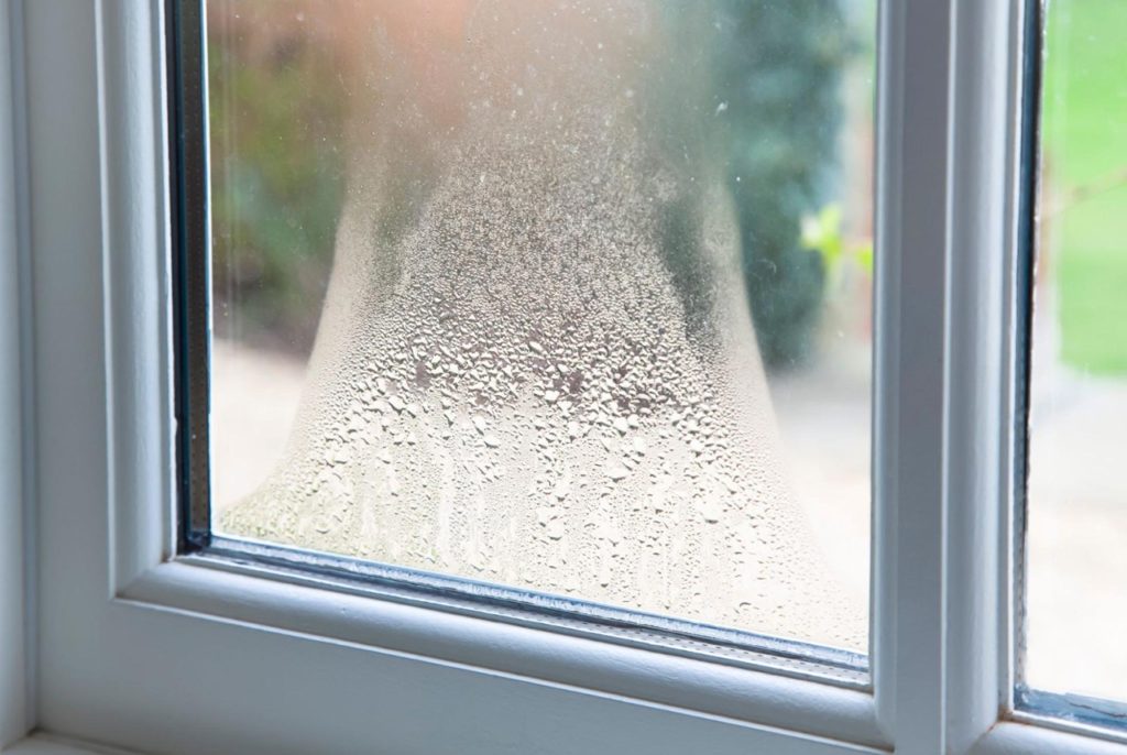 Window condensation accumulates on a pane of glass.