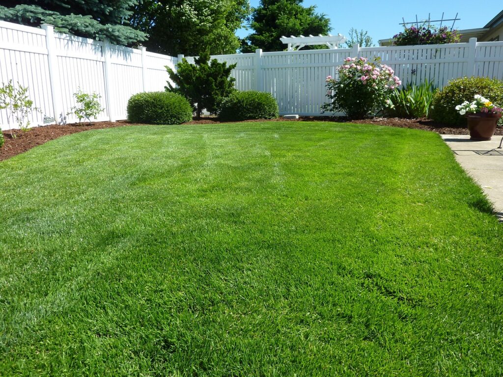 white vinyl privacy fence surrounds a backyard