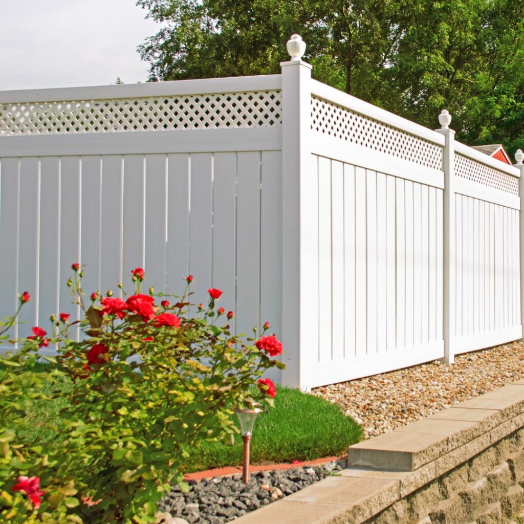 Enhancing Your Backyard with Vinyl Fences: Ideas for Long Island Outdoor Spaces - Unified Home Remodeling A white vinyl fence borders a Long Island flower garden