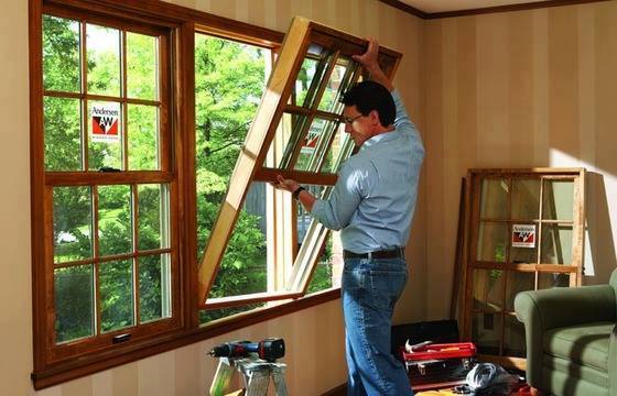 man installing Andersen wood window inserts in Long Island, NY home