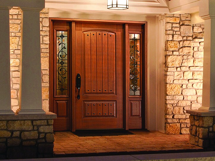 Woodgrain entry door design with ornate grilles
