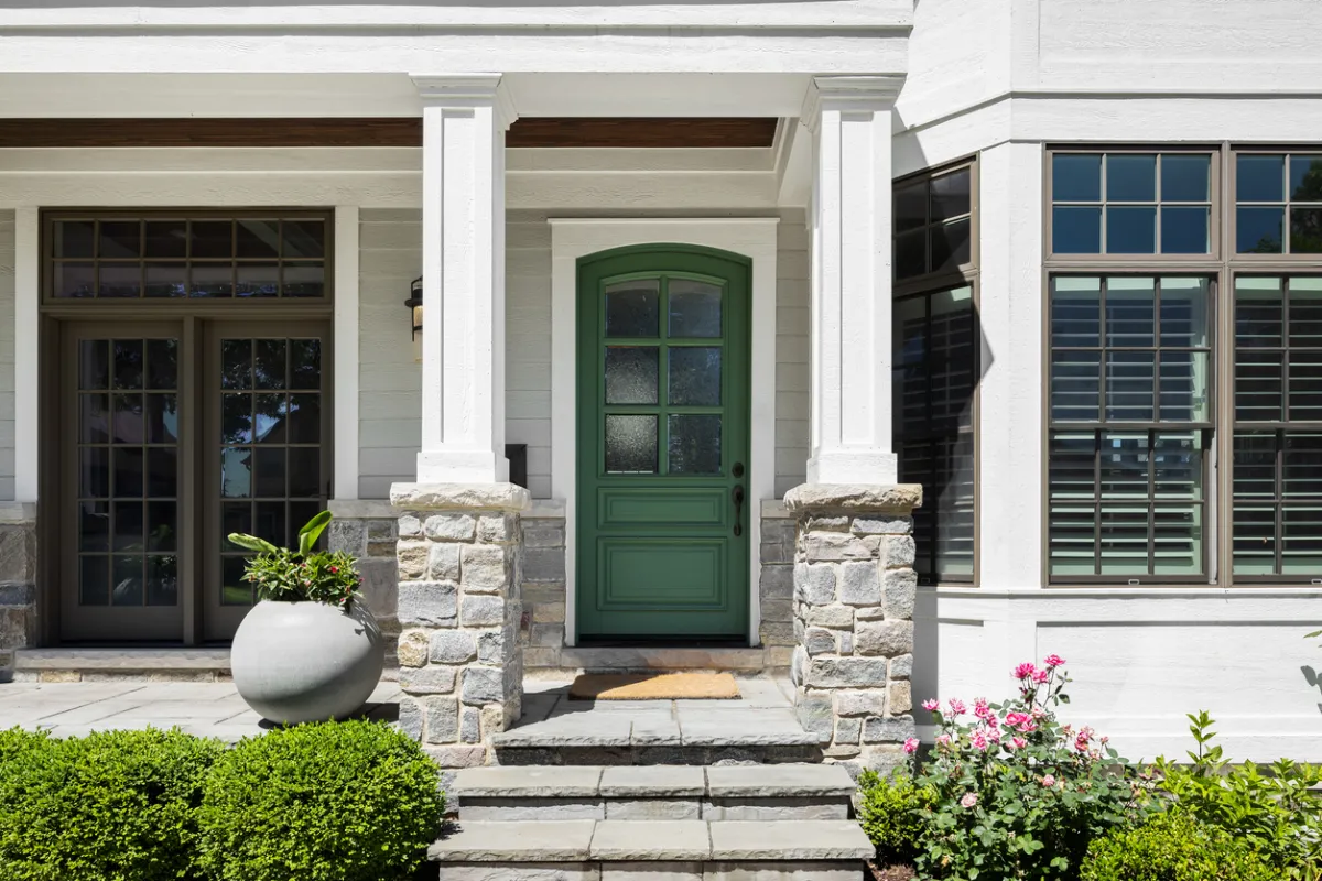 Services - Unified Home Remodeling Front entry of a Long Island home with stone paver steps, green door, and stone pillars
