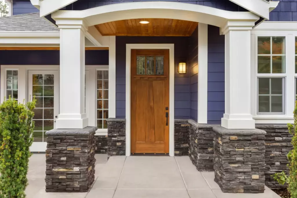 Mid-range wood entry door replacement on Long Island with covered porch and sidelights nearby