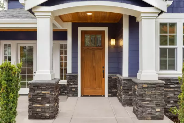 Mid-range wood entry door replacement on Long Island with covered porch and sidelights nearby