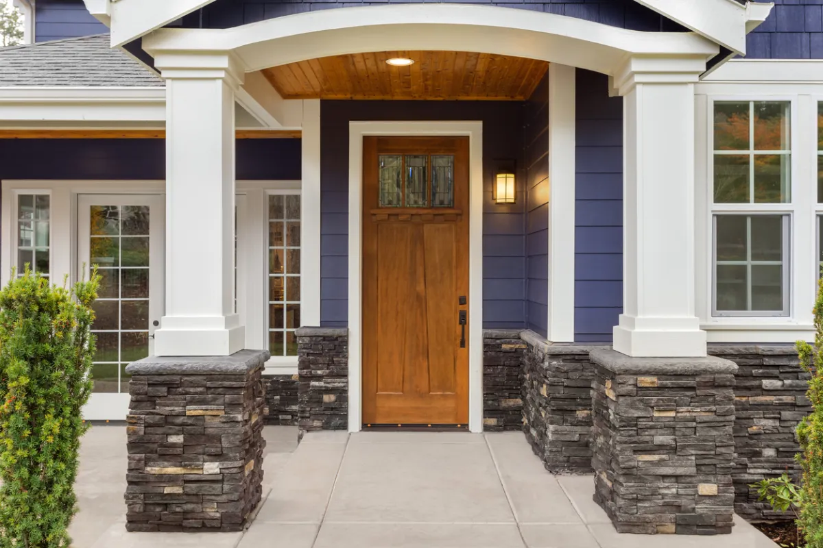 Mid-range wood entry door replacement on Long Island with covered porch and sidelights nearby