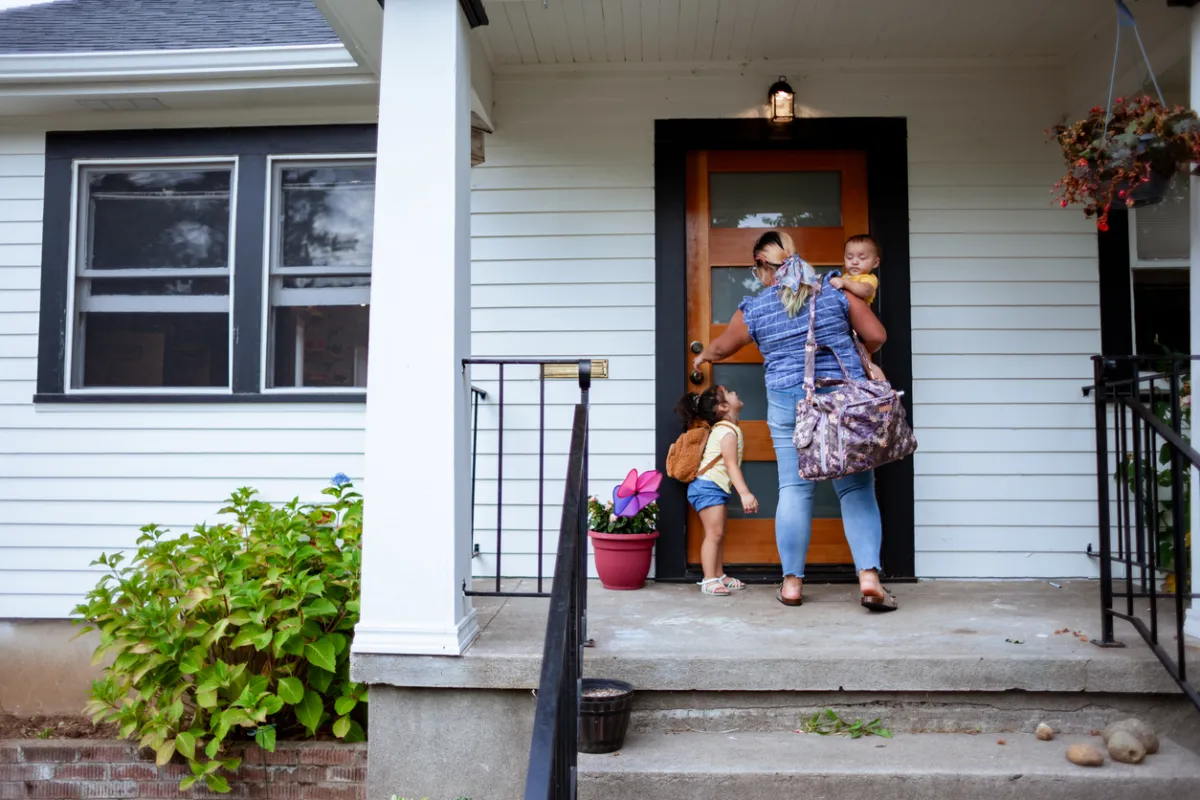 family entering home through modern fiberglass entry door on long island.