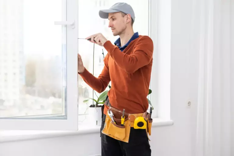 Window Replacement - Unified Home Remodeling window installer adjusting replacement window frame inside a Long Island home
