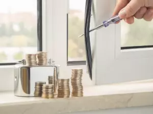 Replacement window and stacked coins representing replacement window costs for Long Island homeowners.