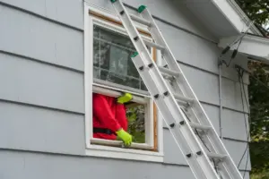 Window installer replacing a second-floor window on a Long Island home.