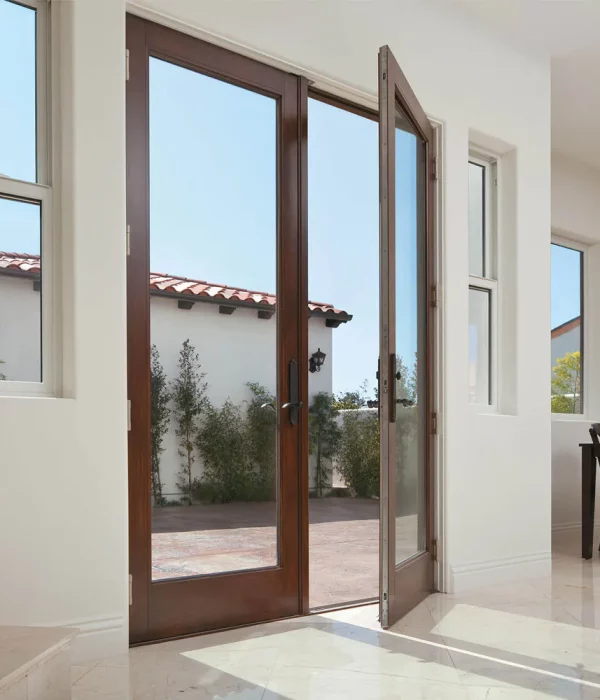 Hinged patio door installation in a Nassau County home featuring full glass panels and wood interior finish.
